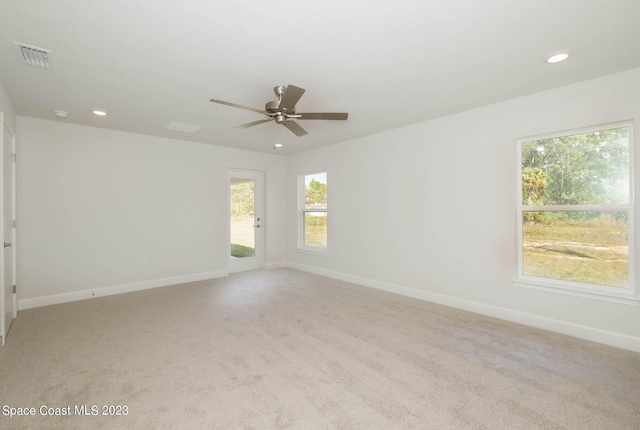 spare room with ceiling fan and light colored carpet