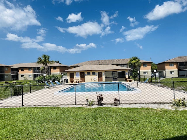 view of pool featuring a lawn