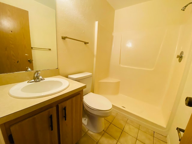 bathroom with toilet, tile patterned flooring, a shower, and vanity