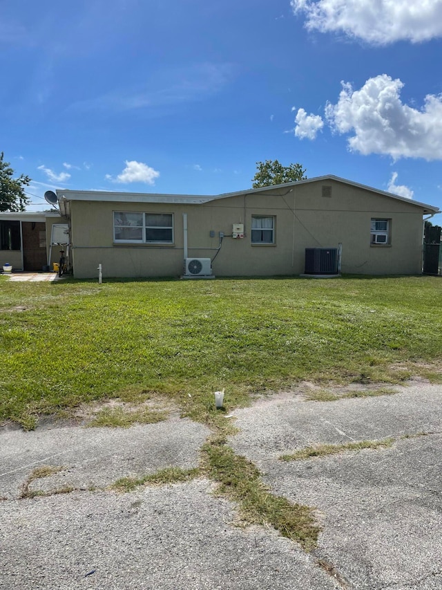 rear view of house featuring a yard and cooling unit