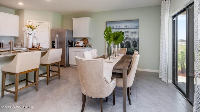 dining space featuring light tile patterned floors and sink