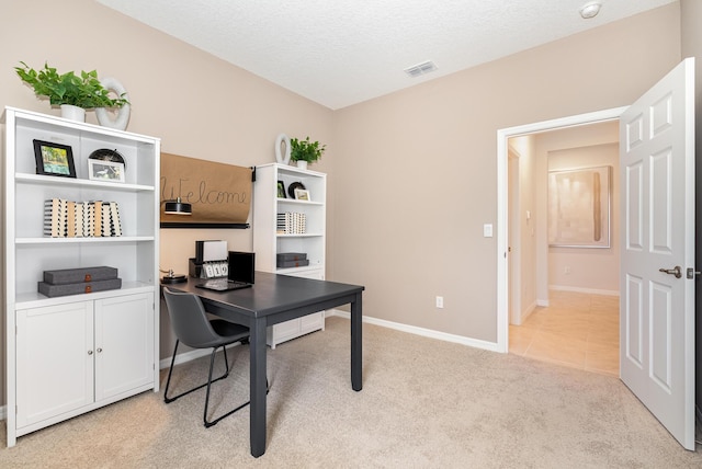 carpeted office space featuring a textured ceiling