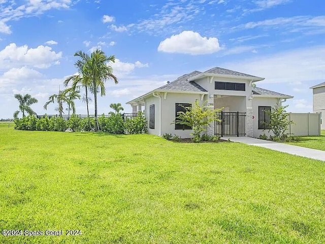 view of front of house featuring a front yard, fence, and stucco siding