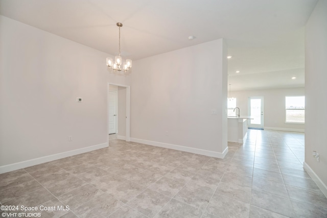 unfurnished room featuring light tile patterned flooring, recessed lighting, a sink, baseboards, and an inviting chandelier