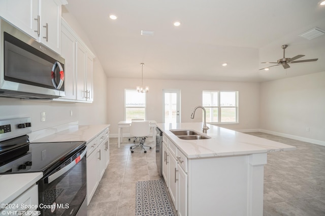 kitchen featuring a kitchen island with sink, a sink, white cabinetry, appliances with stainless steel finishes, and pendant lighting