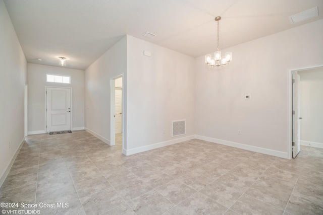 entrance foyer featuring baseboards, visible vents, and a notable chandelier