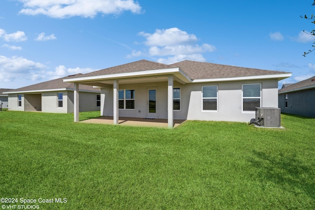 rear view of property with a patio area, stucco siding, a lawn, and central AC unit