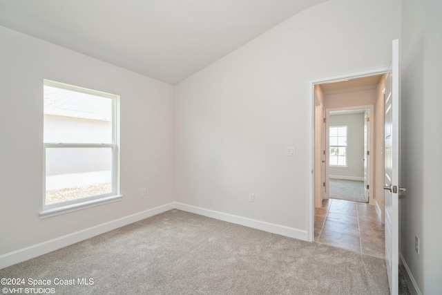 2283 Middlebury Dr SE, Palm Bay, FL 32909 - spare room with light carpet, baseboards, and lofted ceiling