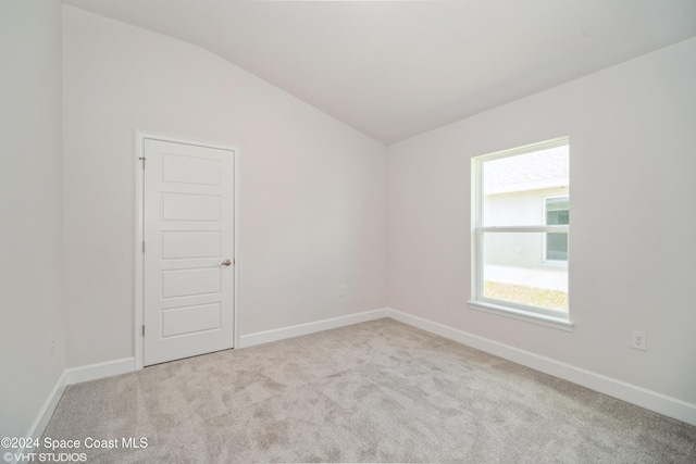 2283 Middlebury Dr SE, Palm Bay, FL 32909 - spare room featuring lofted ceiling, carpet floors, and baseboards