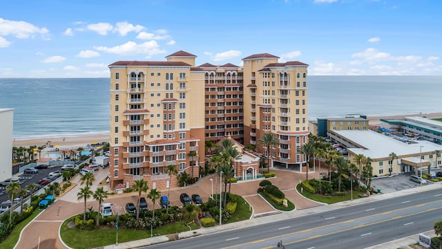 view of building exterior featuring a water view and a view of the beach