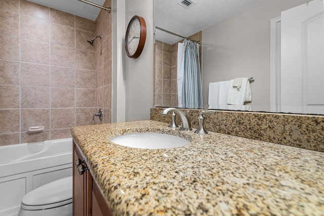 full bathroom featuring visible vents, toilet, vanity, shower / bath combo with shower curtain, and a textured ceiling