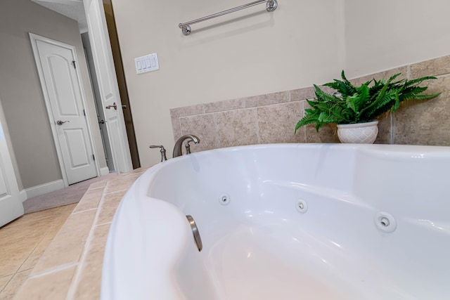 bathroom with a washtub and tile patterned floors