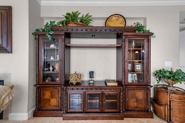 bar with light tile patterned flooring, ornamental molding, and dark brown cabinets