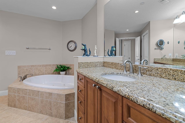 bathroom with vanity, tile patterned floors, tiled bath, and a textured ceiling