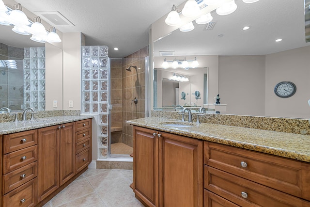 bathroom featuring vanity, tile patterned floors, a textured ceiling, and walk in shower