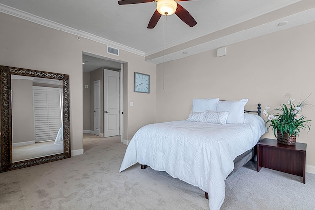 carpeted bedroom featuring visible vents, ceiling fan, crown molding, and baseboards