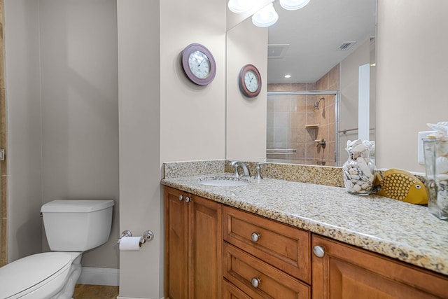 bathroom with visible vents, baseboards, toilet, a stall shower, and vanity