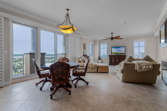 tiled dining space with ceiling fan, a textured ceiling, built in features, and ornamental molding