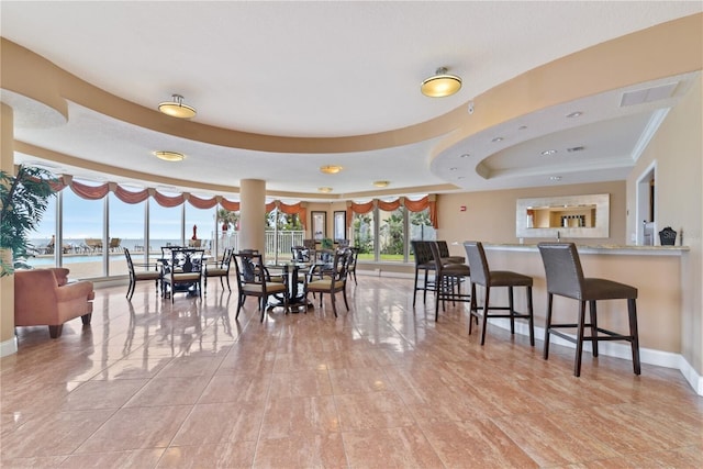 dining room featuring a raised ceiling, visible vents, and baseboards