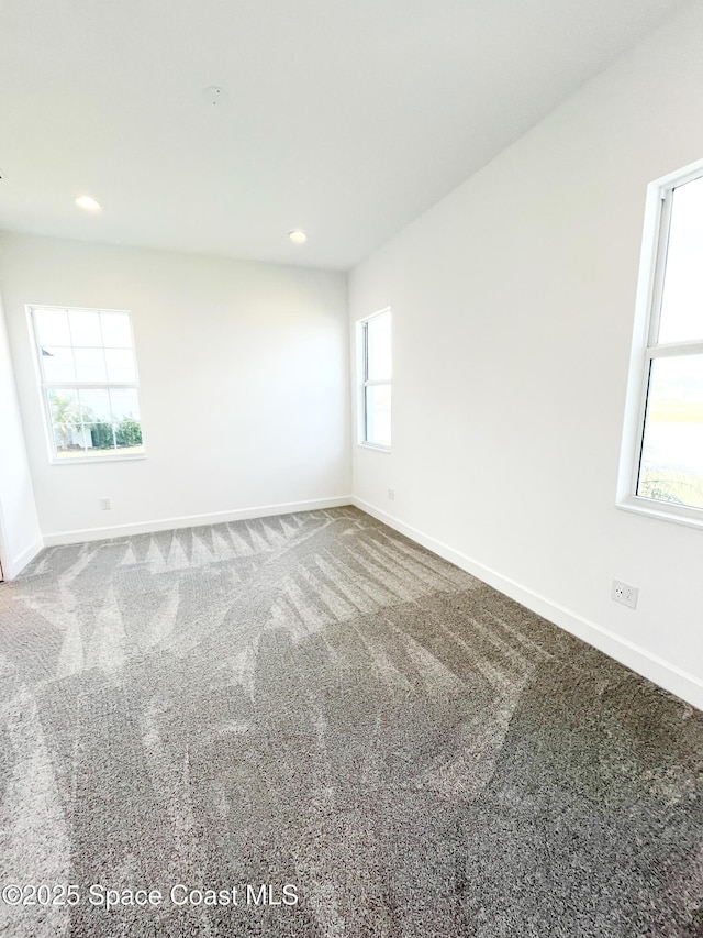 spare room featuring carpet floors, recessed lighting, and baseboards