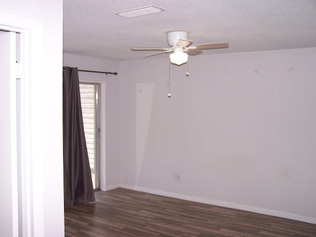 spare room featuring dark wood-style floors, ceiling fan, a textured ceiling, and baseboards