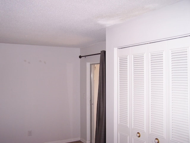 unfurnished bedroom with a textured ceiling and a closet