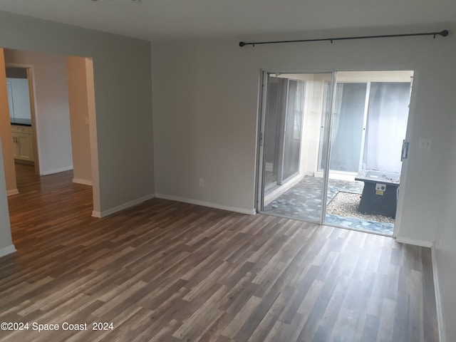 spare room with wood finished floors and baseboards