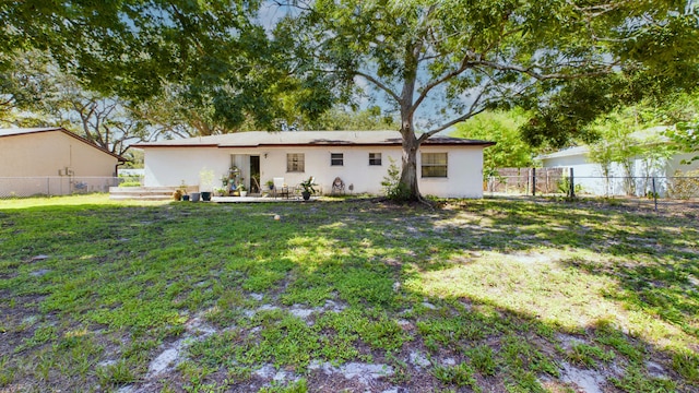 rear view of property featuring a lawn