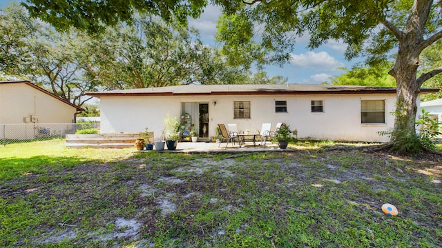 back of house featuring a patio and a lawn