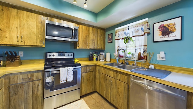 kitchen with sink, stainless steel appliances, and light tile patterned flooring