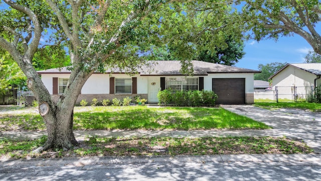 ranch-style house featuring a garage and a front lawn