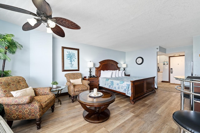 bedroom featuring ceiling fan, a textured ceiling, and light wood-type flooring