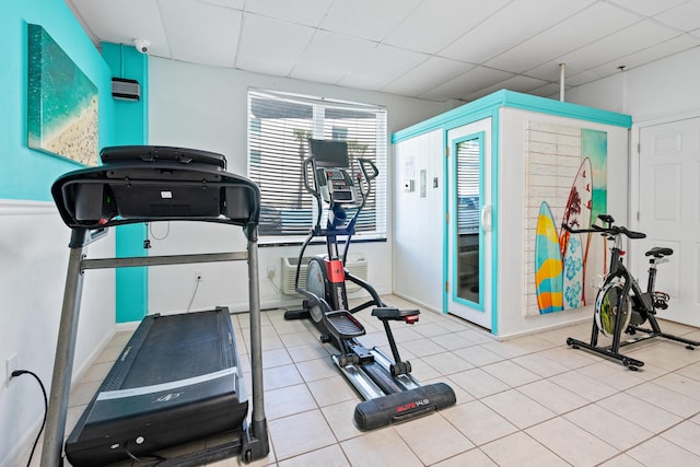 workout room with a drop ceiling and light tile patterned floors