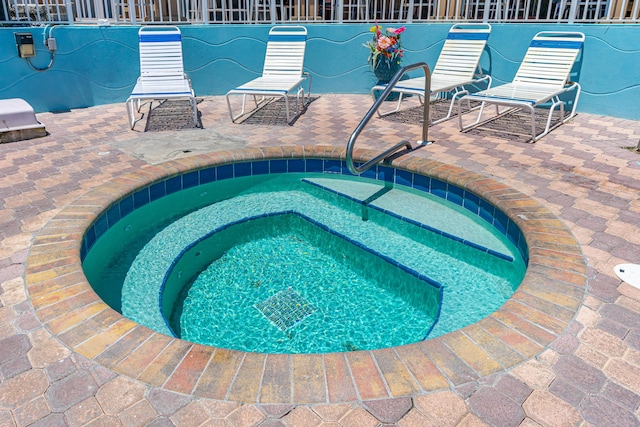 view of swimming pool featuring a hot tub