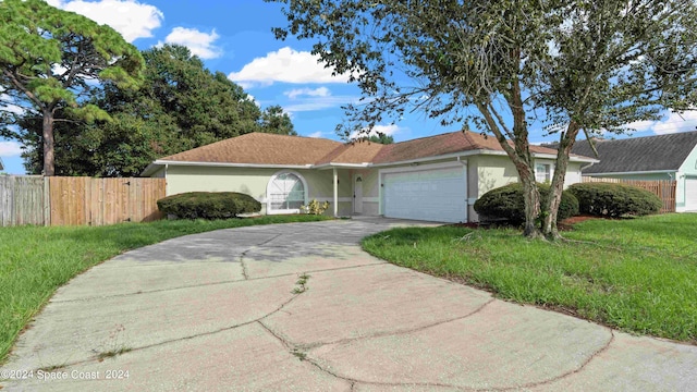 ranch-style house featuring a front yard and a garage