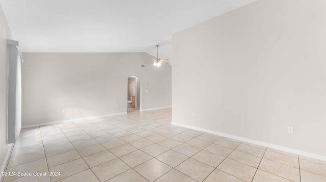 unfurnished room with ceiling fan, light tile patterned flooring, and vaulted ceiling