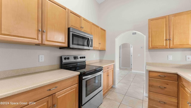 kitchen featuring stainless steel appliances and light tile patterned flooring