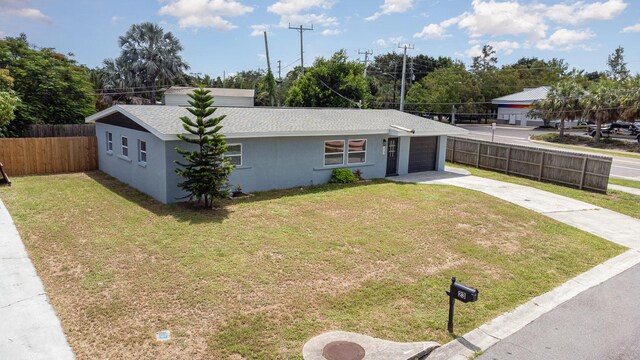 single story home featuring a garage and a front yard