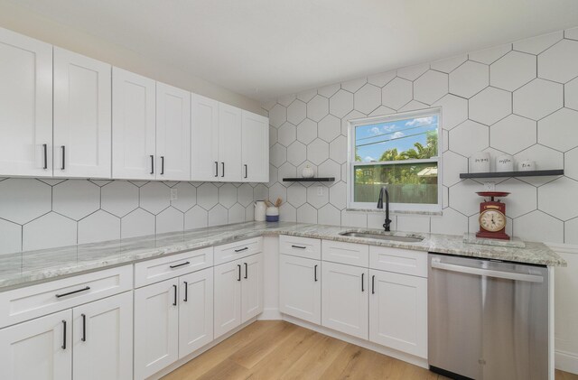 kitchen with decorative backsplash, light hardwood / wood-style floors, dishwashing machine, and sink