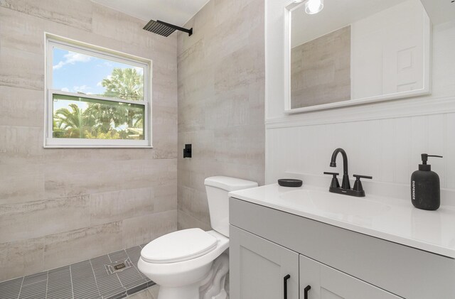 bathroom featuring tiled shower, vanity, and toilet