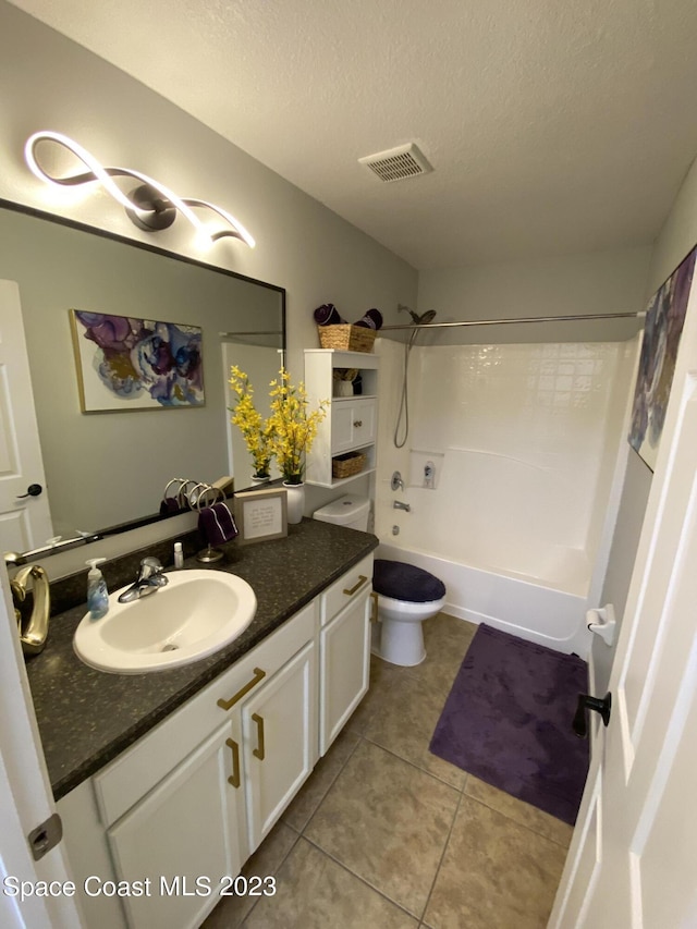 full bathroom featuring toilet, vanity, tile patterned floors, shower / bathing tub combination, and a textured ceiling