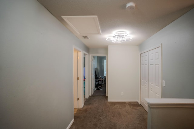 hallway with dark colored carpet