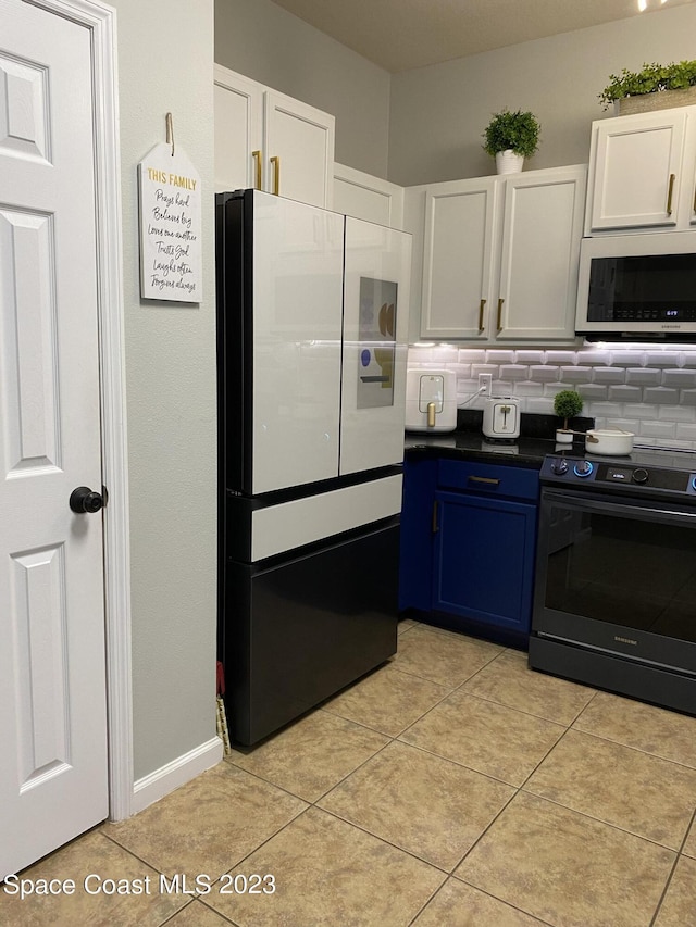 kitchen featuring electric range oven, white cabinetry, decorative backsplash, fridge, and blue cabinets