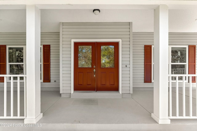 entrance to property featuring covered porch and french doors