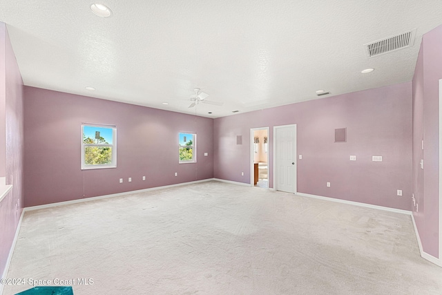 unfurnished room featuring ceiling fan, light colored carpet, and a textured ceiling