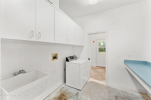 clothes washing area with washer / clothes dryer, sink, cabinets, and a textured ceiling