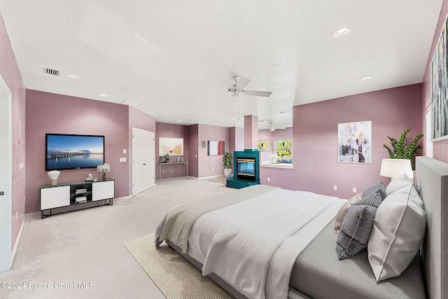 bedroom with ceiling fan and a textured ceiling