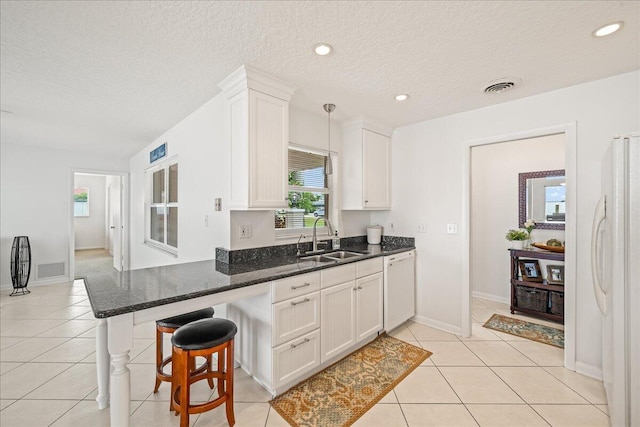 kitchen with hanging light fixtures, sink, white cabinets, and white appliances