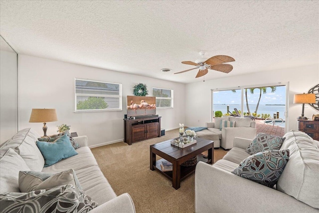 living room featuring light carpet, ceiling fan, and a textured ceiling