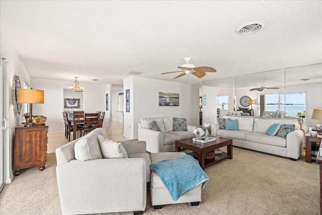 carpeted living room featuring ceiling fan and a textured ceiling